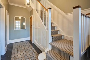 A staircase with a patterned carpet and a wooden handrail.