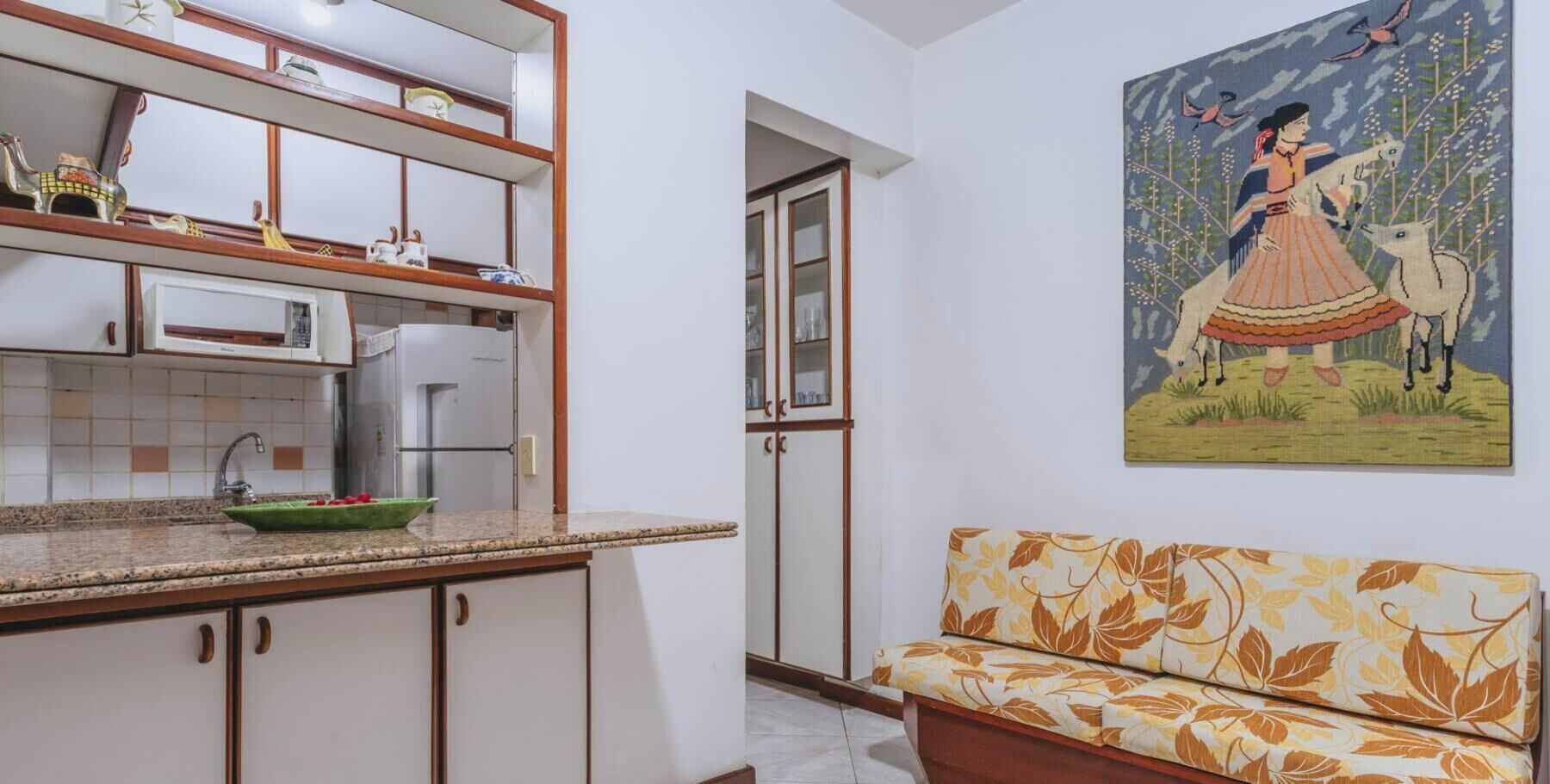 A kitchen with white cabinets, a microwave, and a green bowl on the counter.