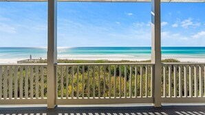 Un espacio al aire libre techado con vista a una playa y al océano.