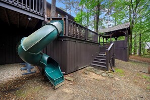 A playground with a slide and stairs leading to a covered area. - # Time Well Spent  ## Luxury Broken Bow Cabin with Hot Tub, Creek, Playground, a (Broken Bow)