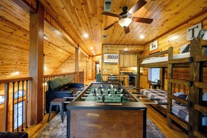 Ein gemütliches Blockhaus mit Kicker, einer Couch und Stockbetten.