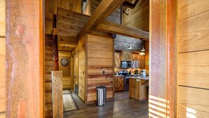 A wooden interior with a kitchen area, including cabinets, a microwave, and a sink. - Burnt Whiskey! Beautiful Rustic Couples Cabin. (Broken Bow)