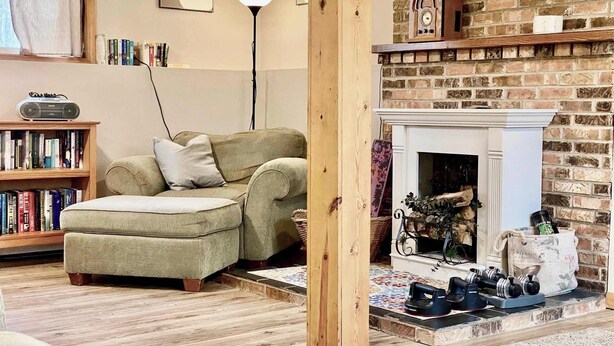 A cozy living room with a fireplace, a bookshelf, and a radio. - Spacious 4BR Escape in Sherwood Forest (Grayling)