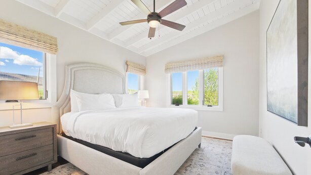 A bedroom with a large bed, a ceiling fan, and two windows with blinds. - Afton Mountain Vineyards (Afton)