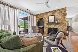 Una sala de estar moderna con chimenea de piedra, asientos cómodos y un televisor.