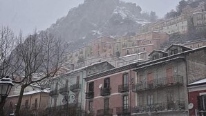 A row of traditional buildings with balconies, set against a backdrop of a snow-covered mountain. - tartufo hotel (Colliano)