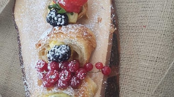 A wooden serving board with pastries and berries.