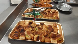 A buffet table with various baked goods, including pastries and bread rolls, arranged on trays. - tartufo hotel (Colliano)