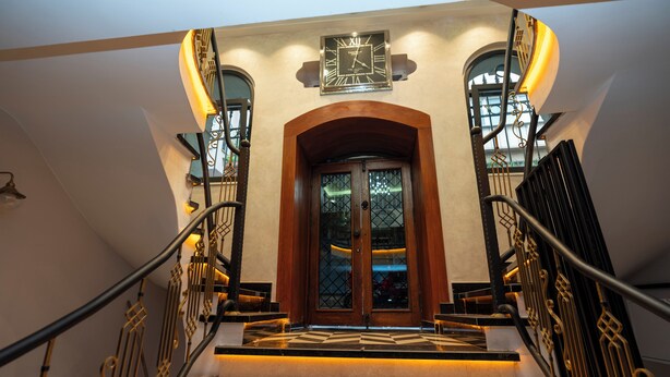 A grand staircase with ornate metal railings and a wooden door at the top. - The Mua Luxury Homes (Istanbul)