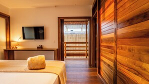 Une chambre d’hôtel avec un lit, un téléviseur fixé au mur et un plancher en bois.