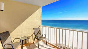 A balcony with a view of the ocean, featuring two chairs and a table. - Seacrest 905 by Liquid Life (Gulf Shores)