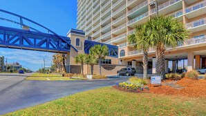 A hotel with a multi-story structure, a covered walkway, and a parking area. - Crystal Tower 807 by Liquid Life (Gulf Shores)