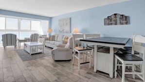 A living room with a dining table, chairs, a sofa, and a coffee table.