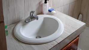Ein Badezimmer mit Waschbecken, Spiegel und Duschvorhang.