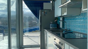 Una cuina moderna amb vista a un paisatge urbà a través de grans finestres.