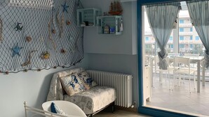 Un dormitori amb un llit, un radiador, una finestra amb cortines i vista a l'exterior.