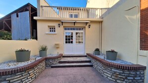 A building with a white door, stone steps, and potted plants. - Gîte de l'olivier, reception room, parties and ceremonies, events. (Saint-Brisson-sur-Loire)