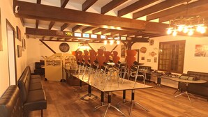 A restaurant with a long table, chairs, and a booth seating area. - Gîte de l'olivier, reception room, parties and ceremonies, events. (Saint-Brisson-sur-Loire)