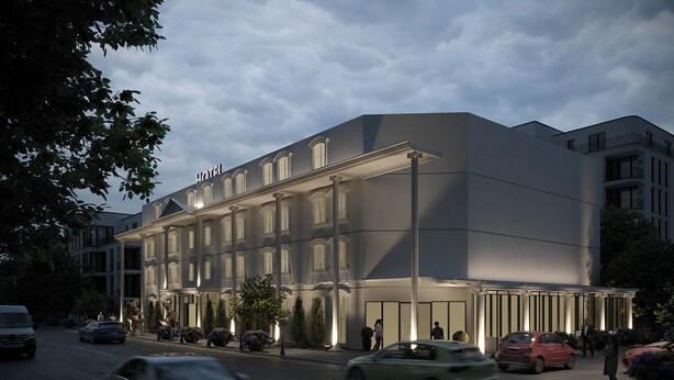 Un hôtel moderne à la façade symétrique, doté de grandes fenêtres et d’une entrée centrale.
