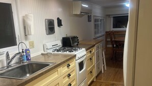 A kitchen with a gas stove, sink, and dishwasher. - Charming 1-bedroom house with WiFi, AC in enchanting Burnsville (Burnsville)