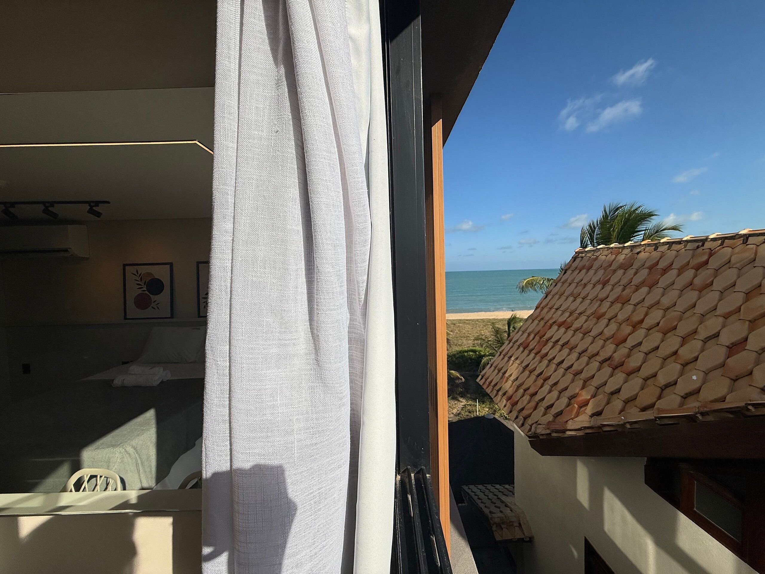 A balcony with a view of the beach and ocean.