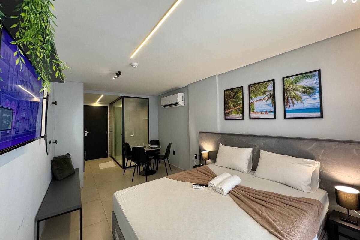 A modern hotel room with a bed, bedside lamps, a desk, and a chair.