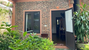 Una casa con facciata in mattoni, una porta in vetro e il numero 102 ben visibile.