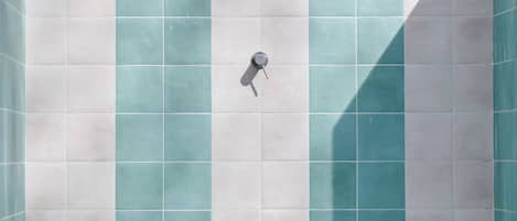 A tiled shower area with a handheld showerhead.