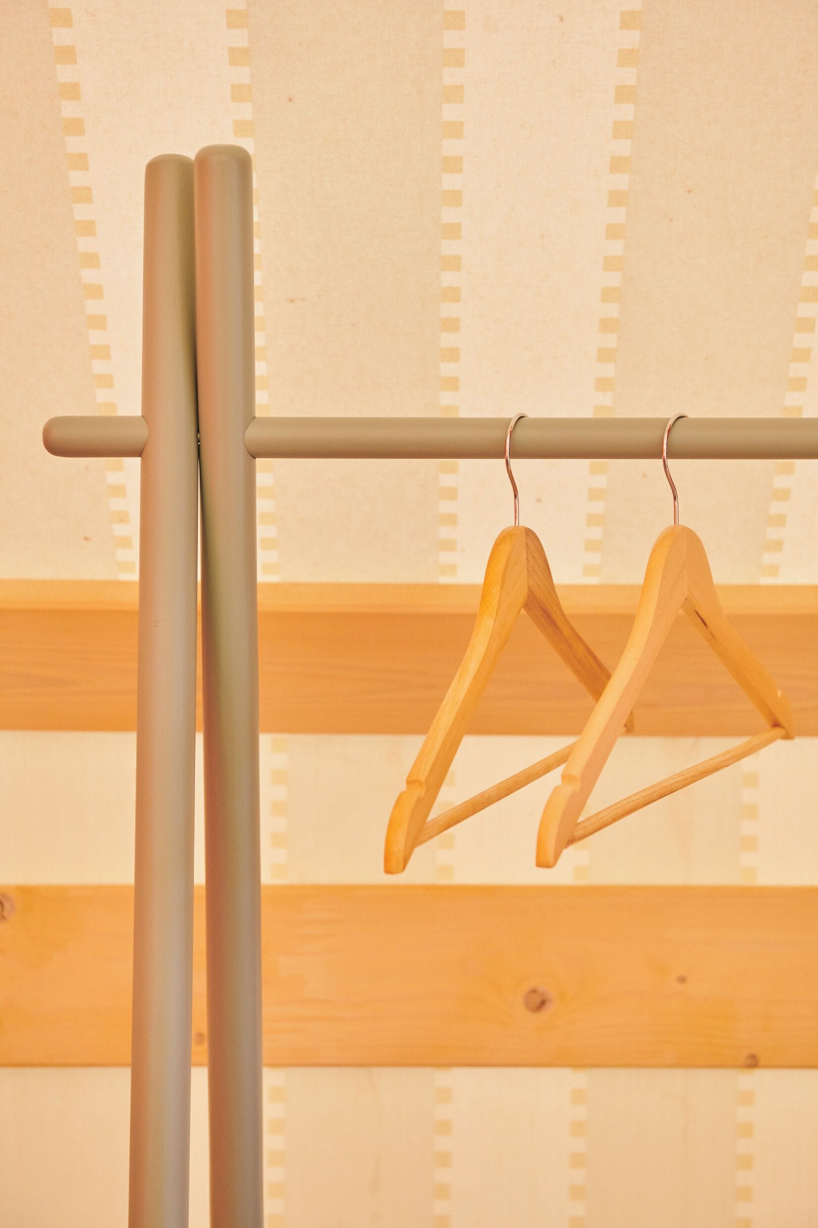 A metal rod with two wooden hangers attached to it.