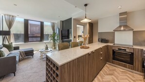 Een moderne keuken met een centraal eiland, een inbouwoven en een groot raam.
