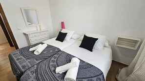 Una habitación de hotel con una cama, un tocador, un espejo y una ventana.