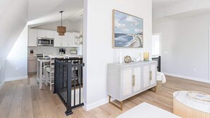A modern kitchen with white cabinets, a microwave, and a hanging light fixture. - Downtown Newport Penthouse (Newport)