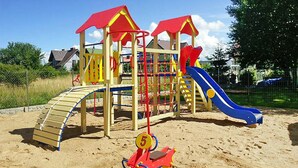 Ein Spielplatz mit Rutsche, Klettergerüsten und Sandkasten.