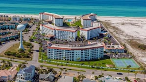 Un complejo turístico con varias edificaciones, una playa y un tanque de agua.