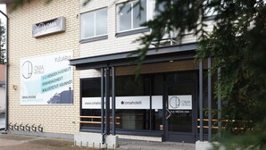 A hotel with a signboard displaying its name and contact information. - Oma Hotelli  (Ylojarvi)