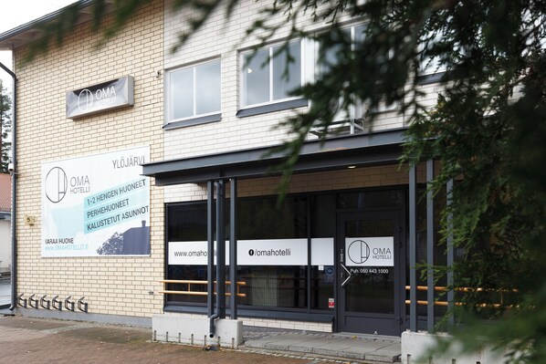 A hotel with a signboard displaying its name and contact information. - Oma Hotelli (Ylojarvi)