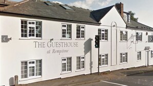 Een wit gebouw met het bord "THE GUESTHOUSE at Rempstone" op de gevel.