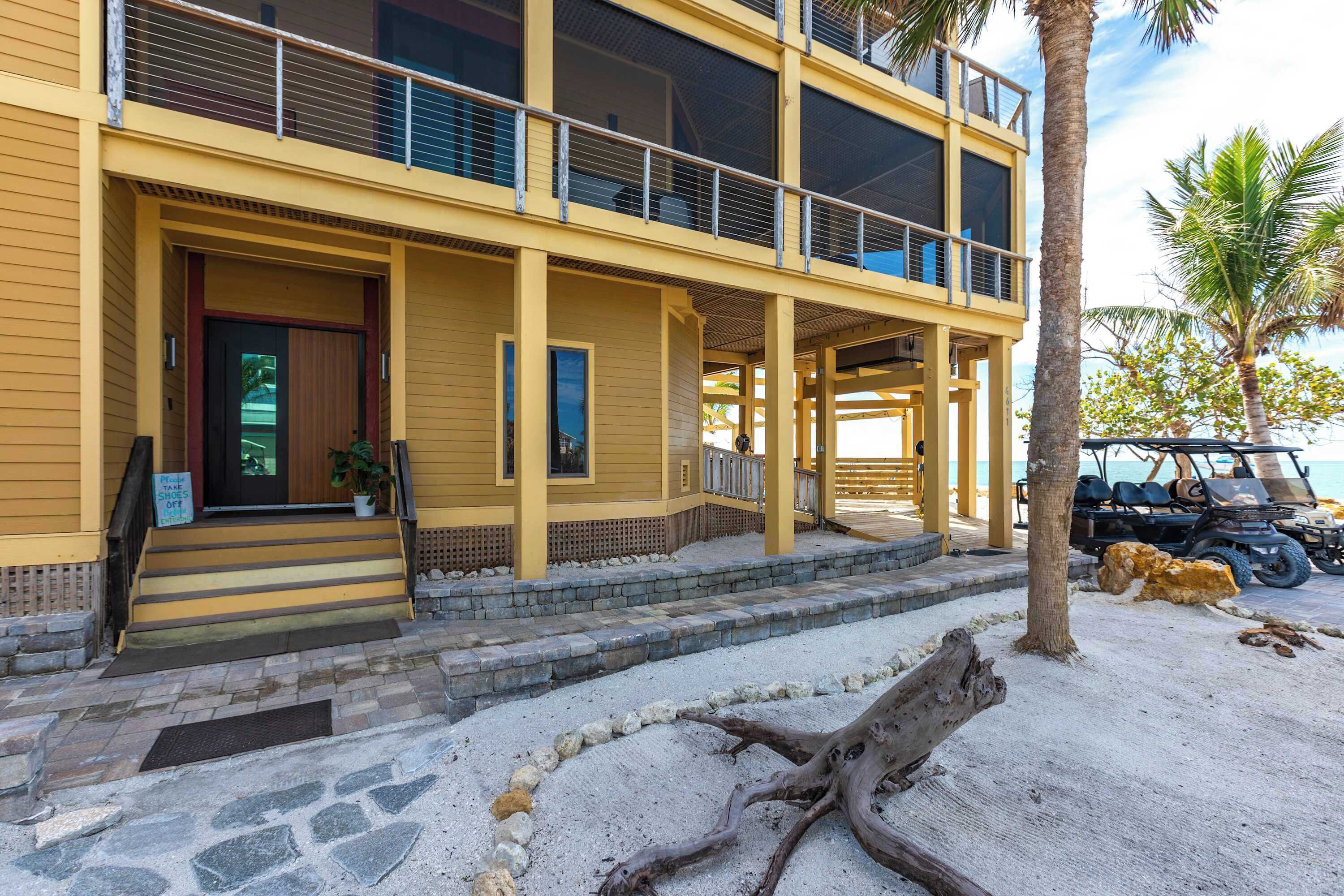 A two-story building with a balcony, a sign indicating 'Take Shoes Off', and a golf cart parked nearby.