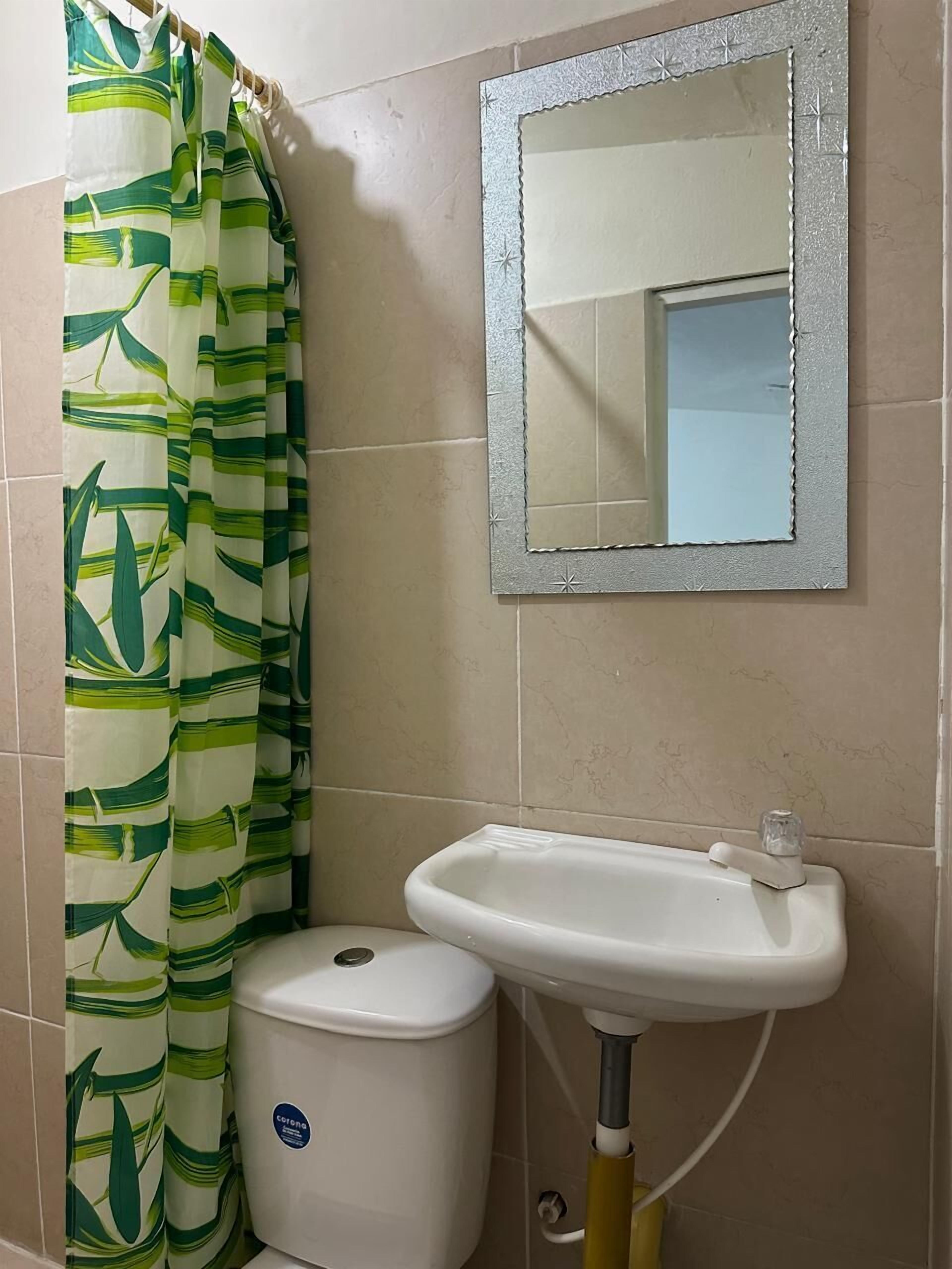 Un baño con inodoro, lavabo y espejo.