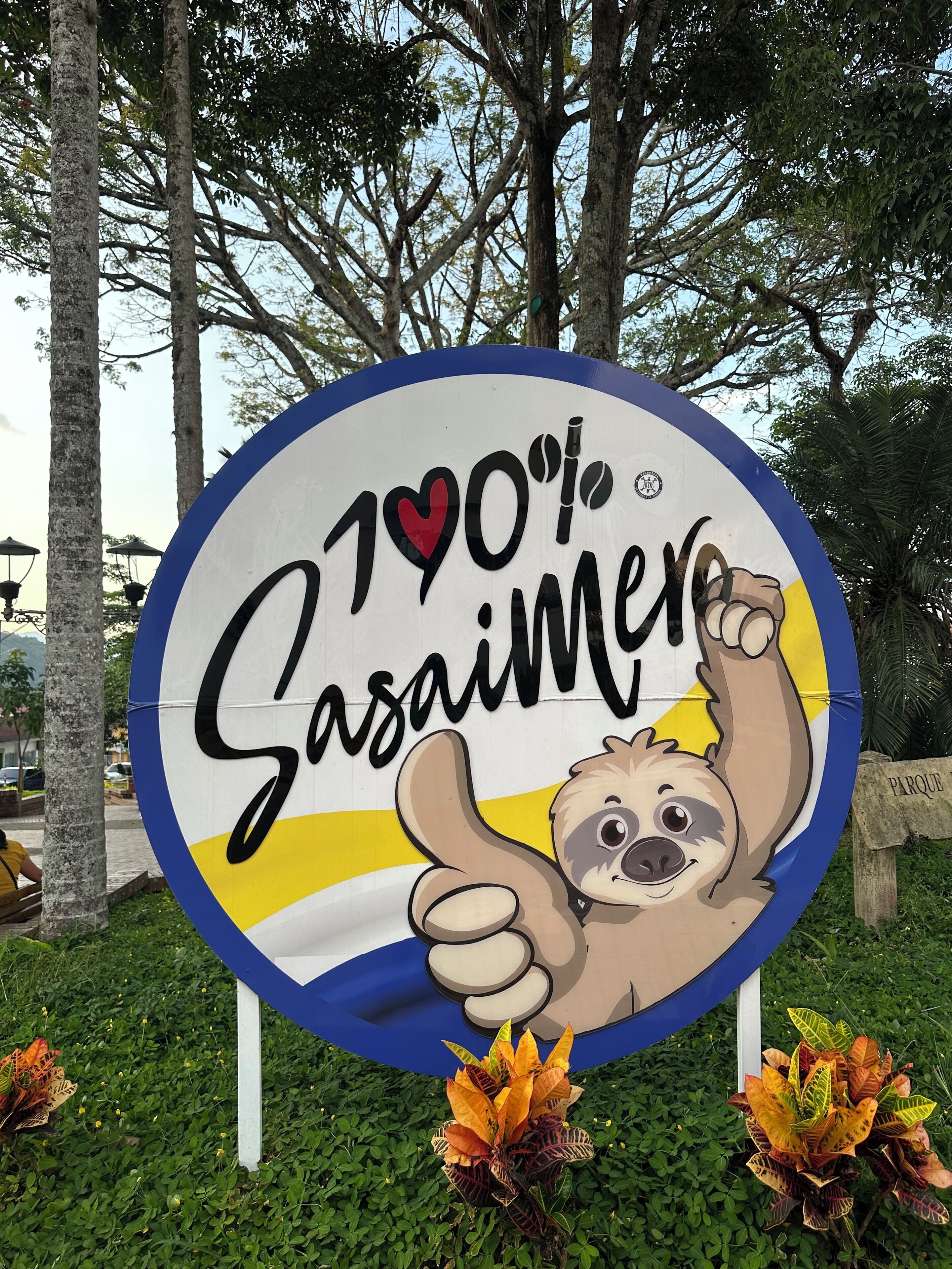 A sign with a sloth graphic, text, and a thumbs-up symbol.