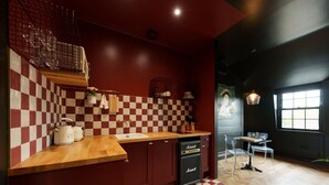 Cozinha com painel de azulejos xadrez, bancada de madeira e lava-louças compacto.