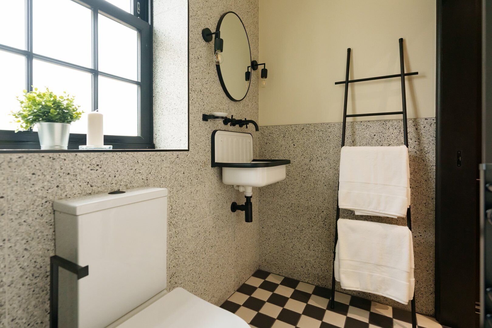 Une petite salle de bain comprenant des toilettes, un lavabo et un porte-serviettes.