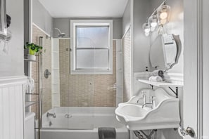 A bathroom with a shower, a bathtub, and a sink.