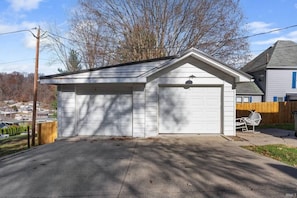 A single-story garage with a white exterior, a sloped roof, and a garage door.