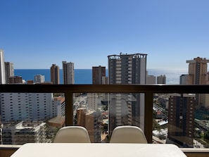 Habitación de hotel en un edificio alto con vistas a la ciudad y al mar.