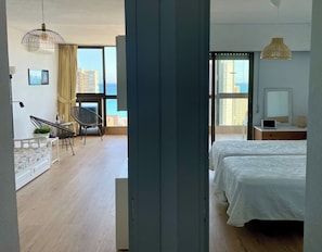 Un dormitorio moderno con una cama grande, televisión y vistas a la ciudad.