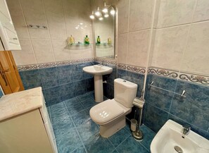 A bathroom with a toilet, sink, and bidet.