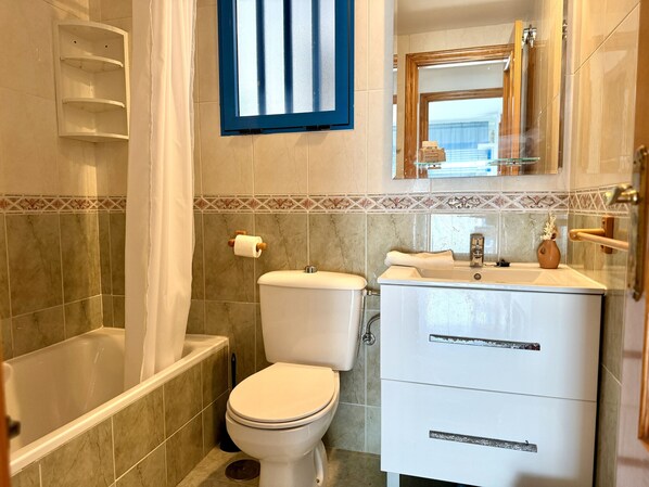 A bathroom with a toilet, sink, and bathtub.