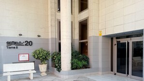 Entrada de un edificio con un cartel que dice "GEMEOS 20 Torre II".