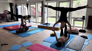A yoga class in a room with large windows, wooden floors, and mats. - La Baleine Blanche (Campan)